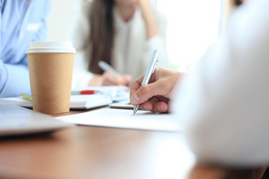 Unrecognizable business person analyzing graphs and taking notes