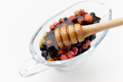 Honey with fresh raw berries forest strawberry. High quality photo