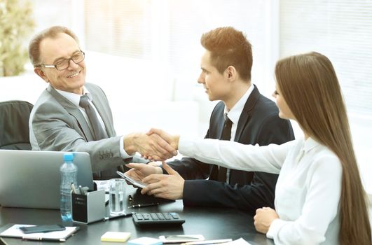 Business people shaking hands making a deal in a modern office