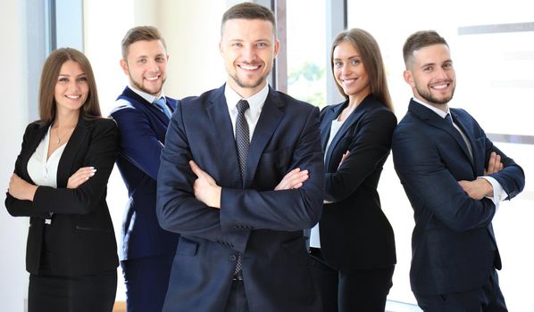 Young businessman standing in office with his collegue on the background