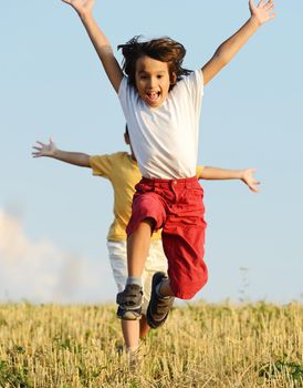 Two little kids on field running together