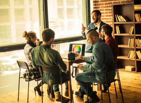 group of designers discussing a new color palette in the workplace in a modern office.