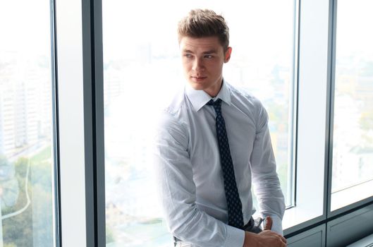 Young handsome businessman smiling in an office environment