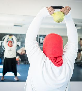 Arabic woman active working out in big gym