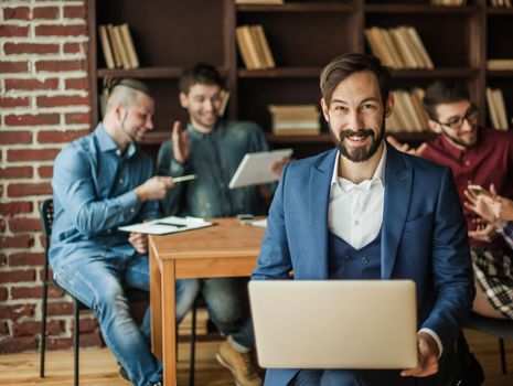 successful employee of the firm with a laptop and a business team discussing the current problems of the company