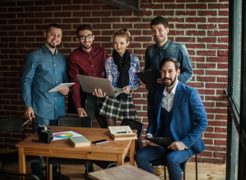 business team with laptop and documents discussing a new project near the workplace in modern office