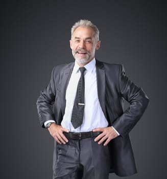 Successful, confident businessman holding his hands at his belt. Isolated on a black background