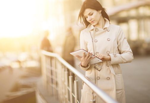 Portrait of business woman with tablet and with people in the background