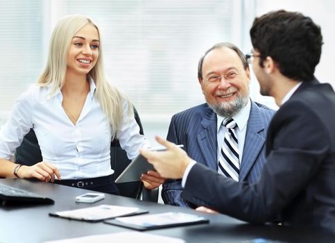 business team is working with financial documents at the office, a discussion between three businessmen