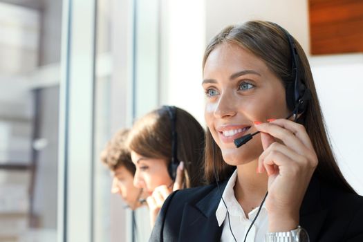 Attractive positive young businesspeople and colleagues in a call center office.