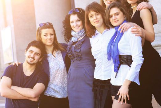 cheerful group of students smiling and looking into the frame. Standing on the street.