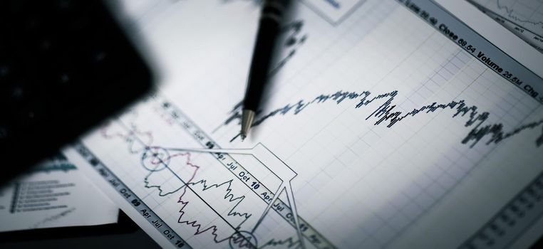 Business graph analysis report. Accounting with pen on documents