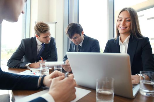 Businesspeople discussing together in conference room during meeting at office.