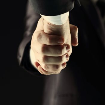 Handshake - Hand on a dark background with tinted in warm tones
