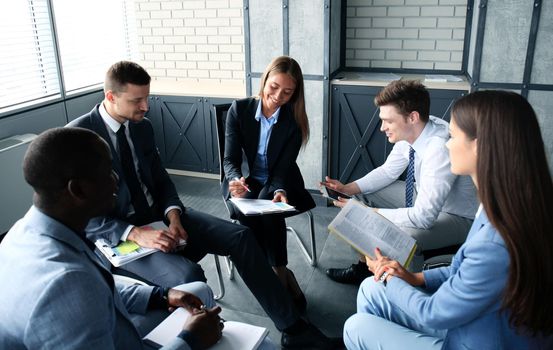 Creative business people meeting in circle of chairs