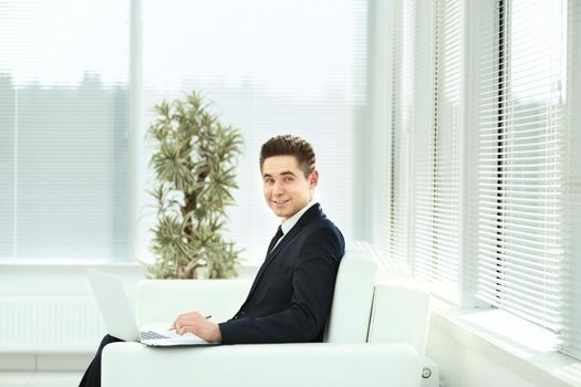businessman in black business suit sitting behind a Desk in the spacious office