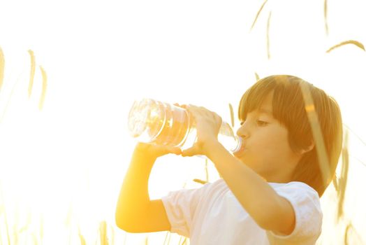 Kid at wheat field drinking water