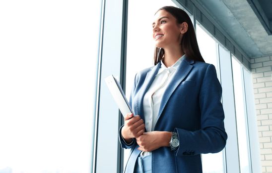 Business lady with positive look and cheerful smile posing for the camera