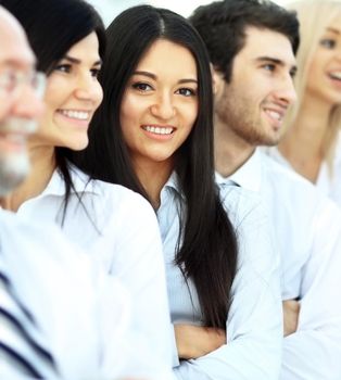 successful and happy business team on office background, girl looks out from the crowd in the frame