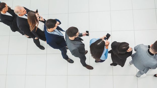 top view. a group of business people looking at their smartphone screens. photo with a copy of the space