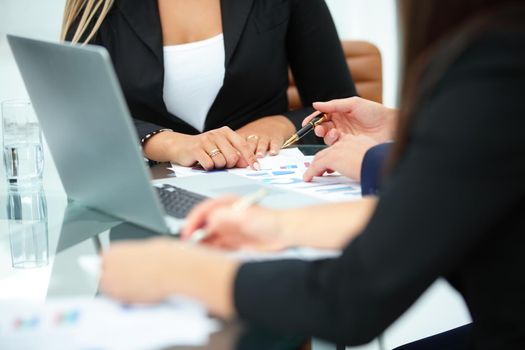 closeup of a group of economists working with financial graphs on the workplace and discussing the development plan of the company