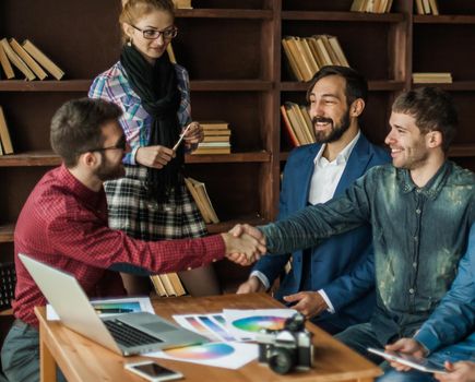 advertising Manager with a handshake greets the customer in a modern office
