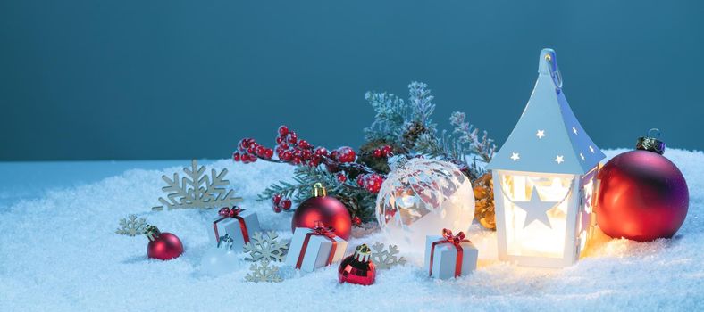 Christmas holidays card with gifts , balls , and white glowing lantern in snow