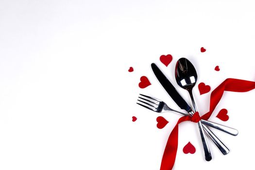 Cutlery set tied with silk ribbon and hearts isolated on white background Valentine day dinner concept