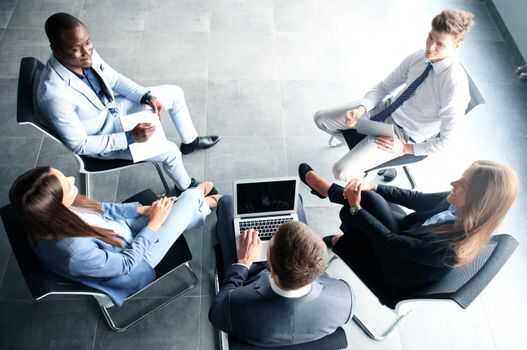 Creative business people meeting in circle of chairs