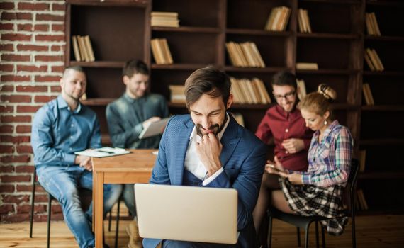 sales Manager with a laptop and a business team discussing the current problems of the company