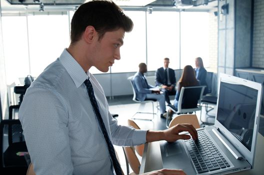 Elegant modern businessman analyzing data while working in office