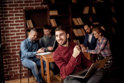 successful employee of the company with laptop on the background of business team.the photo has a empty space for your text