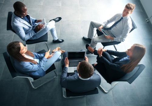 Creative business people meeting in circle of chairs