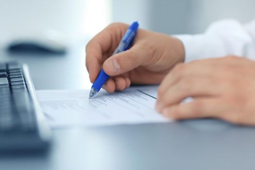 Close-up of female hand holding pen over business document