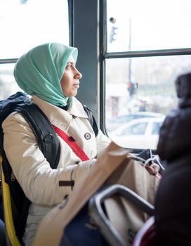 Muslim woman riding public transport in the city