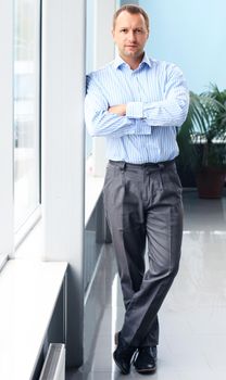 Full length portrait of a mature business man with hands folded