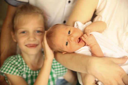 older sister with her newborn sister in the room for children