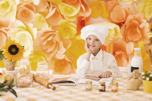 cute little baby prepares delicious meals in the kitchen, smiling and posing for the camera