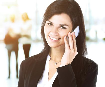 Business woman speaks on the phone in the background Team work in the office