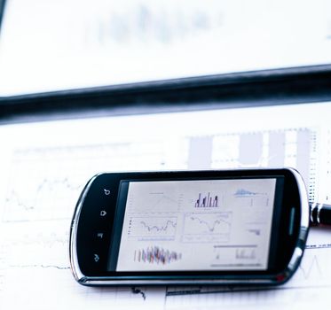 Business chart with a smart phone and a pen in the office