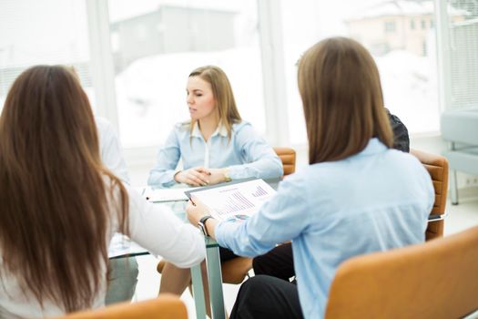 successful business team at a working conference sitting at a Desk and discussing important issues