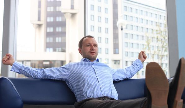 businessman relaxing at the office with his shoes on the desk