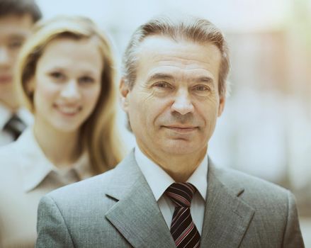 Happy smiling business team standing in a row at office