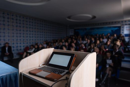 laptop computer at podium on business seminar education  in modern conference room