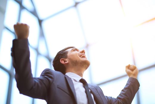 Successful businessman with arms up celebrating his victory