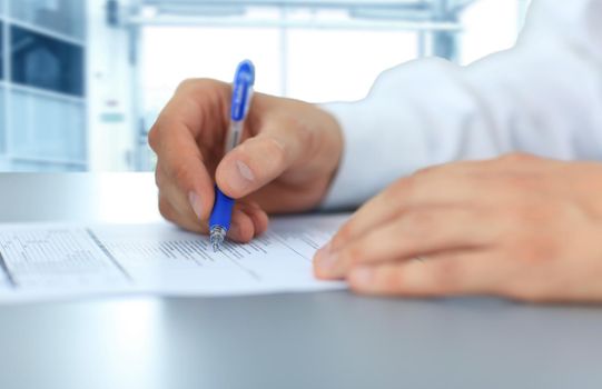 Hands writing on a paper