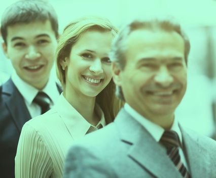 Happy smiling business team standing in a row at the office
