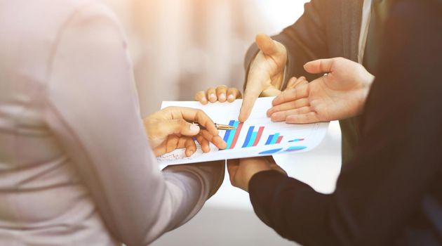 Close-up of graphs and charts analyzed by business people in office