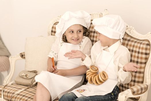 Portrait of happy brother and sister as chef discussing recipes