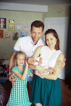 daddy,daughter and mom with a newborn baby in the room for children